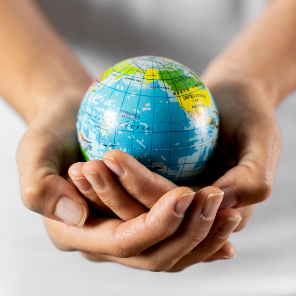 Hands gently holding a globe, symbolizing global care, unity, and responsibility